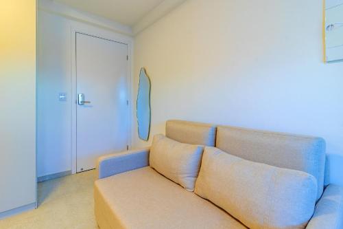 a living room with a couch and a door at Allure Residence by Carpediem in Recife