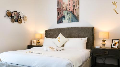 a bedroom with a large white bed with two lamps at 1BR -Marina Solene Yas Island 10 Min to Grand Prix in Abu Dhabi