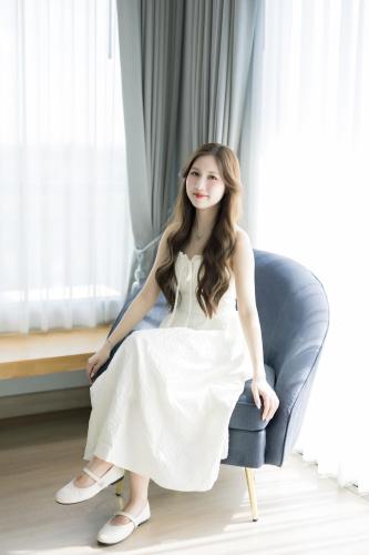 a woman in a white dress sitting in a chair at The Horizon Groove Hotel in Ban Khlong