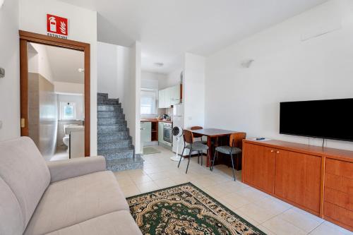 a living room with a couch and a flat screen tv at Residence Brughiera Malpensa in Lonate Pozzolo