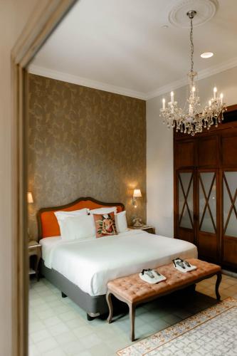 une chambre avec un lit avec une table et un lustre dans l'établissement La Concordia - Boutique Hotel, à Panama City