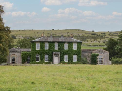 a house covered in green ivy in a field at The Old Kitchen in Grange Over Sands