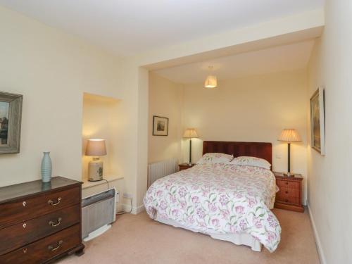 a bedroom with a bed and a dresser and two lamps at The Old Kitchen in Grange Over Sands