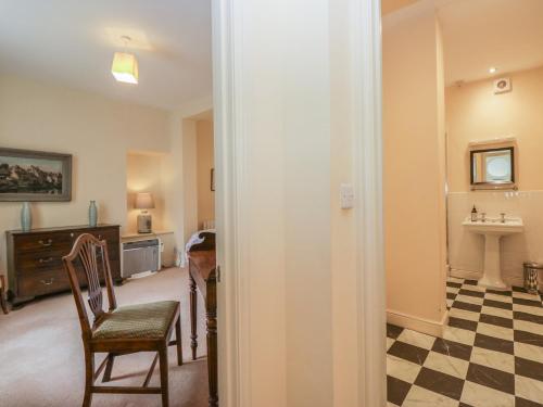 a room with a chair and a table and a sink at The Old Kitchen in Grange Over Sands