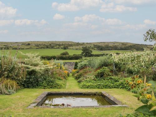a garden with a pond in the middle at The Old Kitchen in Grange Over Sands