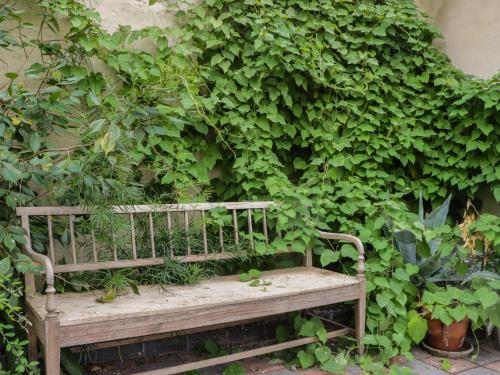 a wooden bench sitting in front of a green wall at The Old Kitchen in Grange Over Sands