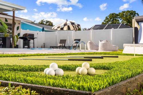 a group of balls sitting on the grass with bats at The Beverley Pool Hot Tub Near Clearwater Beach in Clearwater