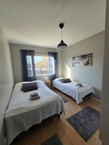 Un dormitorio con dos camas y una ventana. en Apartment Sotilastorpantie, en Kokkola