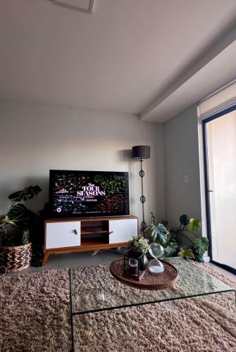 a living room with a large flat screen tv at Cosy Flat Steps from the Beach in Cape Town
