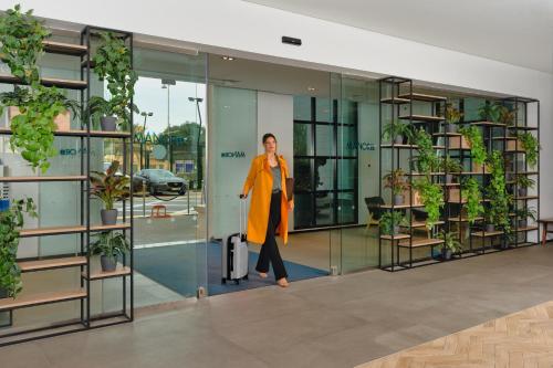 a woman walking through a glass door in an office at JA The Manor Hotel, Dubai in Dubai