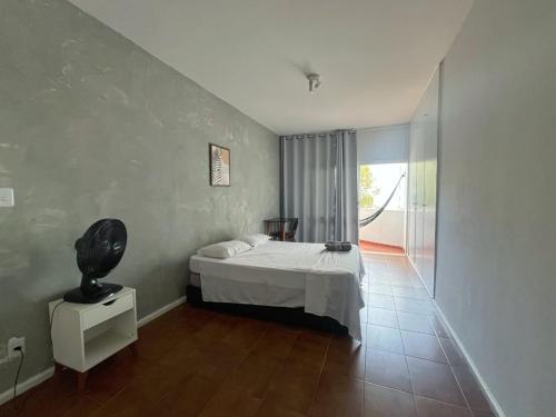 a bedroom with a bed and a large window at Quarto a 150m da Praia do Farol da Barra III in Salvador
