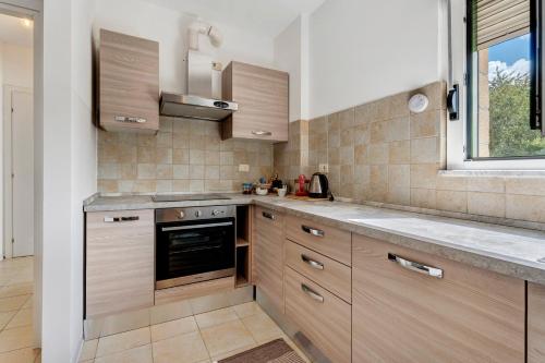 a kitchen with wooden cabinets and a window at Residence Brughiera Malpensa in Lonate Pozzolo