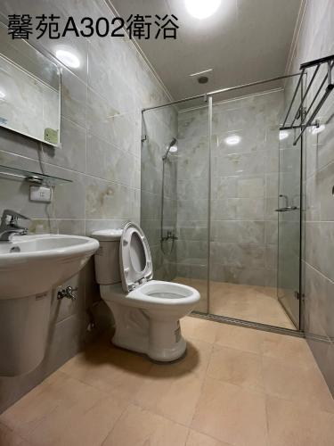 a bathroom with a shower and a toilet and a sink at Xinyuan Guest House in Beidou