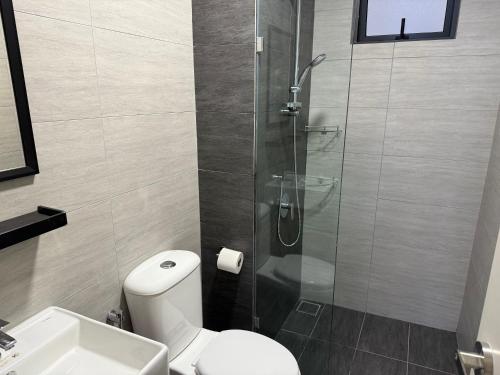a bathroom with a shower and a toilet and a sink at Shelisa's Modern 3BR House at Suria Garden Puchong in Puchong