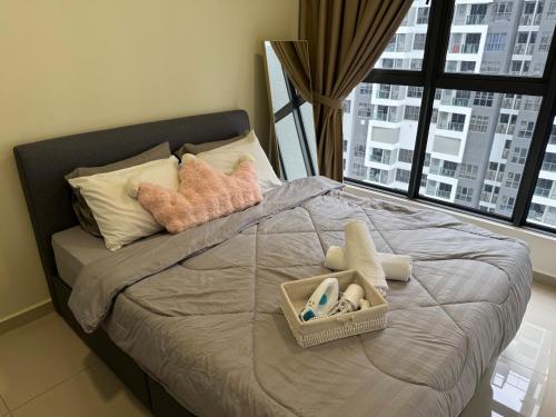 a bed with pillows and a basket of towels at Shelisa's Modern 3BR House at Suria Garden Puchong in Puchong