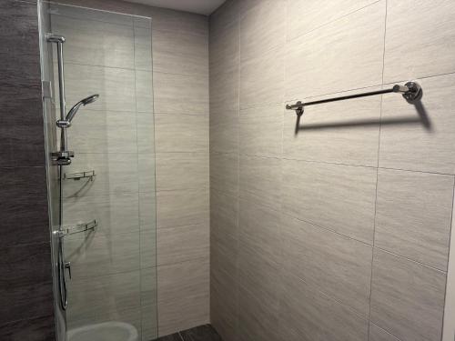 a bathroom with a shower with a glass door at Shelisa's Modern 3BR House at Suria Garden Puchong in Puchong