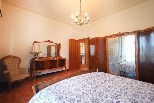 a bedroom with a bed and a mirror and a chair at Villa La Meridiana in Luciana