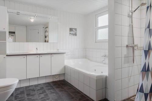 Un baño con bañera, inodoro y lavabo. en 40567-Juelsminde-Pot-Strandby-370, en Sønderby