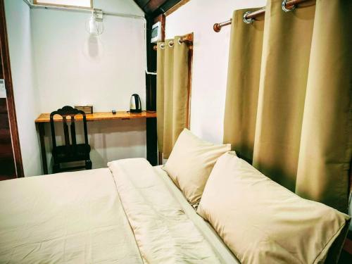 a bed with two pillows sitting in a room at สบาย รีสอร์ท หางน้ำสาคร 