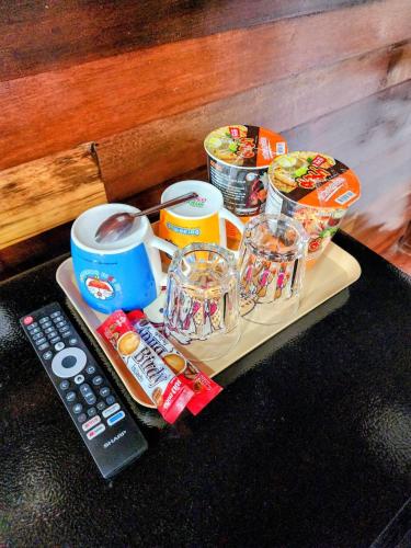 a tray with food and drinks and a remote control at สบาย รีสอร์ท หางน้ำสาคร 