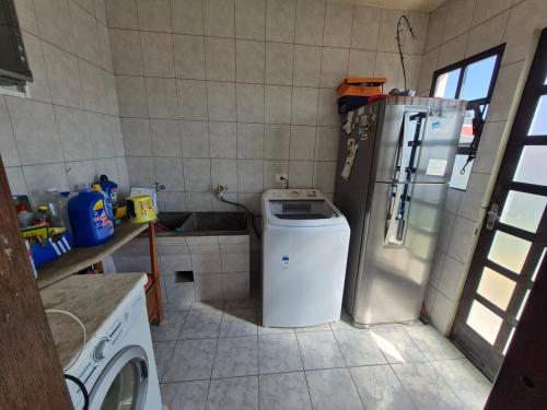 eine kleine Küche mit einem Kühlschrank und einer Waschmaschine in der Unterkunft Pigatto Inn in Campo Largo in Campo Largo