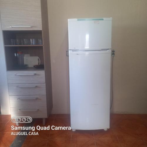 a white refrigerator in the corner of a room at Alojamento para Empreiteira in Sumaré