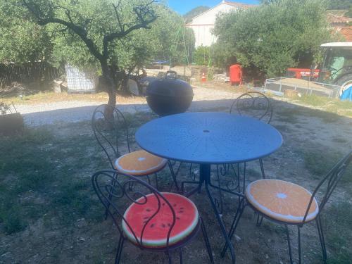 a blue table with four chairs and a vase on it at Maison à Sablet in Sablet