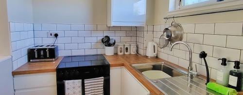 a kitchen with a sink and a counter top at Orchard Cottages at Gorton House in Roslin
