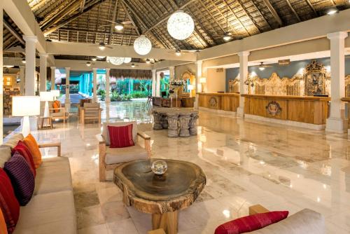 a lobby of a resort with a table and chairs at Iberostar Quetzal in Playa del Carmen