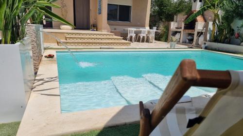 a swimming pool with a swing in front of a house at DAR-Layem in Hanshīr Qaşr Ghallāb