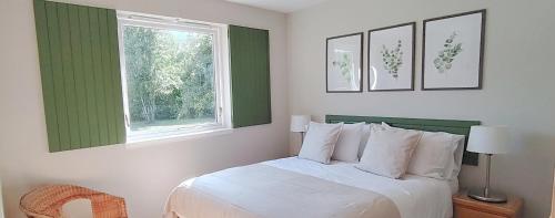 una camera da letto con un letto bianco e una finestra di Gorton House & Orchard Cottages a Roslin