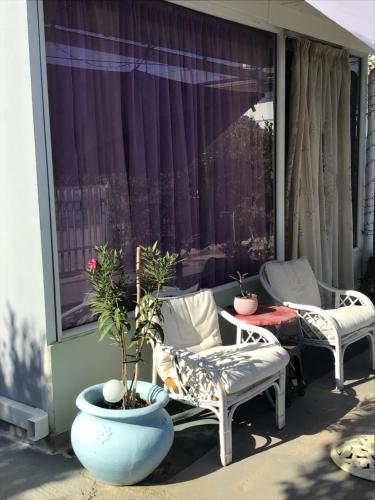 a patio with two chairs and a table and a window at Lidas Sunny Guest House Argolis in Nafplio
