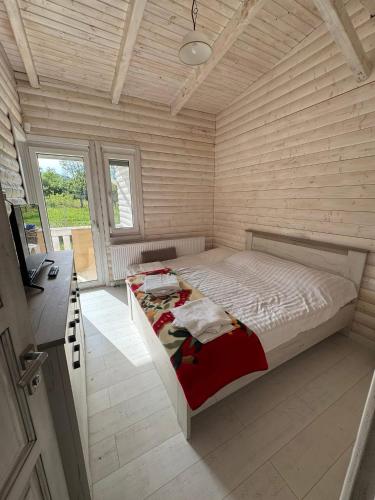 a bedroom with a bed in a wooden room at Cabana Zouk in Poiana Aiudului
