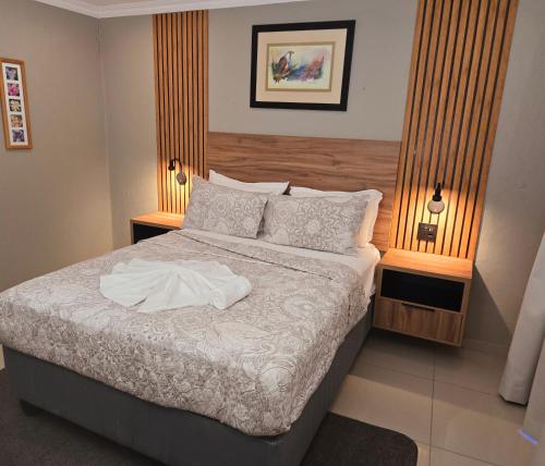 a bedroom with a bed with two lamps on it at Sandown Suites and Conference Centre in Johannesburg