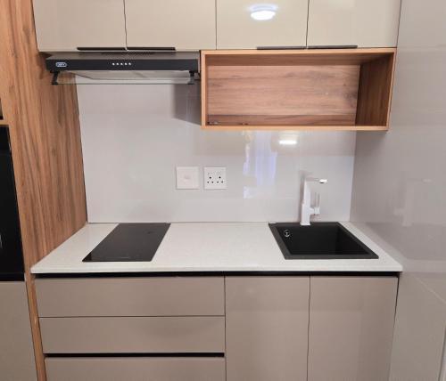 a white kitchen with a sink and a stove at Sandown Suites and Conference Centre in Johannesburg