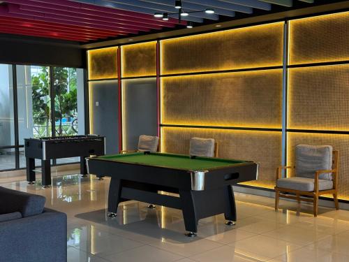 a room with a pool table and some chairs at Shelisa's Modern 3BR House at Suria Garden Puchong in Puchong