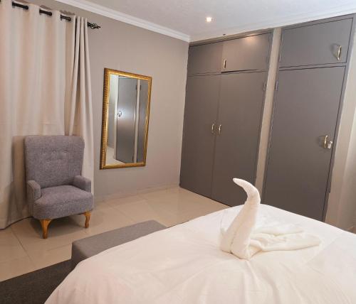 a bedroom with a white bed and a chair at Sandown Suites and Conference Centre in Johannesburg