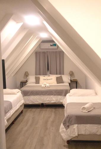 a attic bedroom with two beds in a attic at RIO TIGRE HOTEL in Tigre