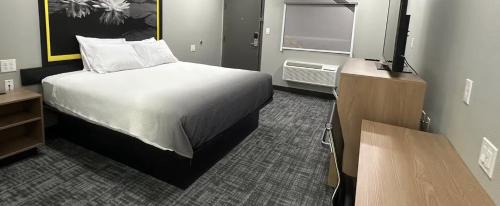 a bedroom with a bed and a flat screen tv at Super 8 by Wyndham Lubbock Airport in Lubbock