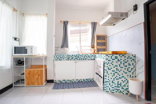 a kitchen with a tiled counter and a window at 640 Villa in Ko Lanta