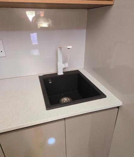 a kitchen counter with a black sink in it at Sandown Suites and Conference Centre in Johannesburg