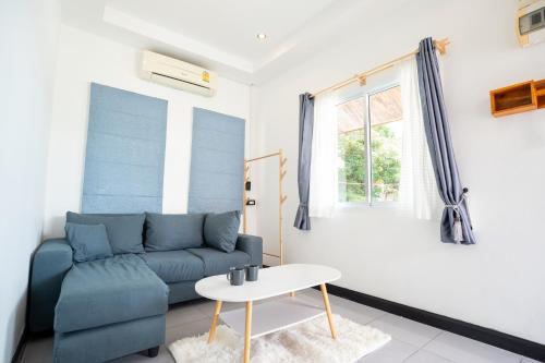 a living room with a blue couch and a table at 640 Villa in Ko Lanta