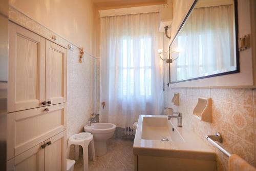 a bathroom with a sink and a toilet and a window at Villa La Meridiana in Luciana