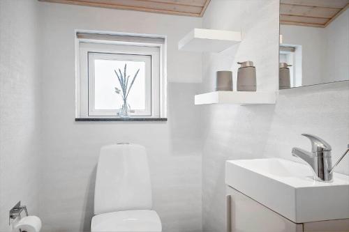 Un baño blanco con inodoro y lavabo. en 40508-Juelsminde-Pot-Strandby-344, en Sønderby
