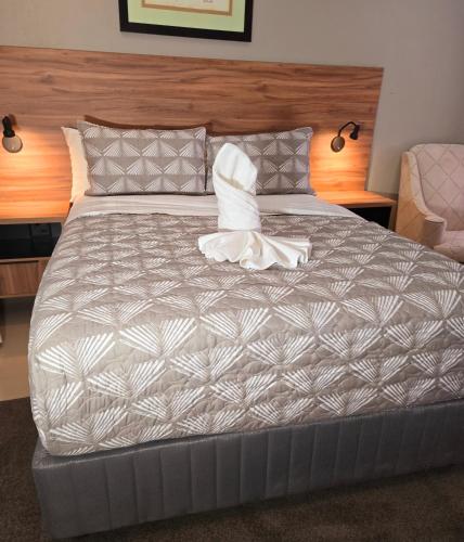 a large bed with a white comforter and pillows at Sandown Suites and Conference Centre in Johannesburg