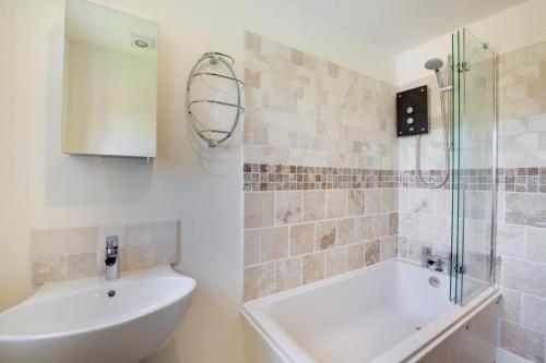 a bathroom with a tub and a sink and a shower at Church View in Heacham