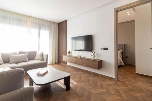 a living room with a couch and a tv at Appartement Anfa Park casa finance City CFC in Casablanca