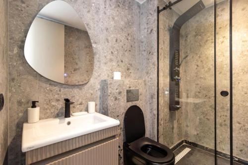 a bathroom with a sink and a toilet and a mirror at Appartement Anfa Park casa finance City CFC in Casablanca