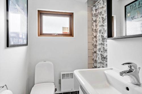 a white bathroom with a toilet and a sink at 30725-Odder-Skovgardsparken-87 in Odder
