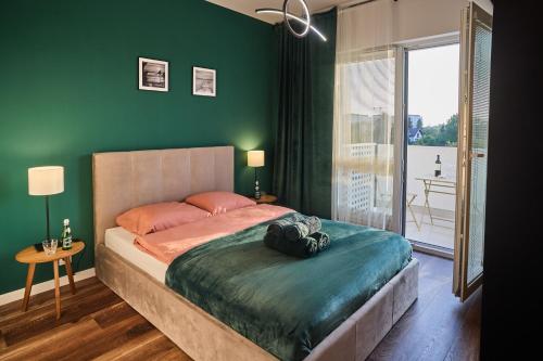 una camera da letto con un letto grande con una parete verde di Apartament dla rodziny Miła 29 C - Rzeszów - Żwirownia - Tyczyn a Rzeszów